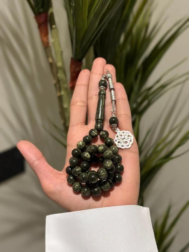 An olive-colored tasbih with a Turkish turban bead