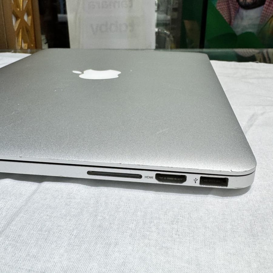 MacBook Pro 2015 with Core i5 processor, 256GB capacity, 12GB RAM, used, scratches on the frame, damaged from behind the Mac