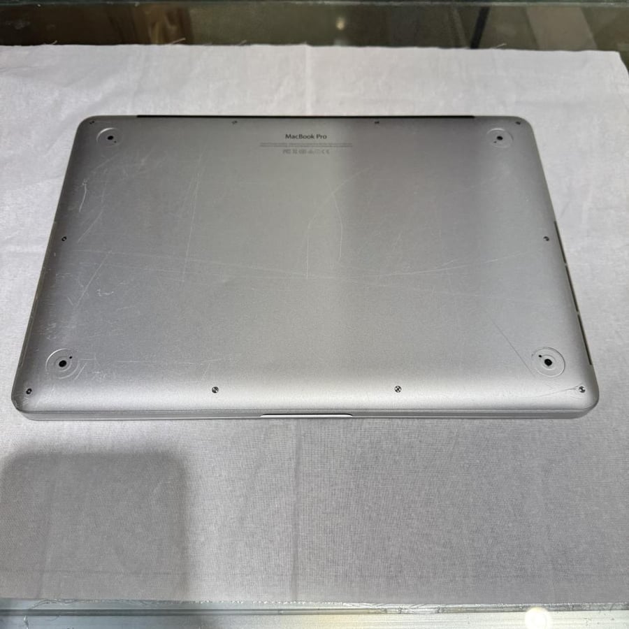 MacBook Pro 2015 with Core i5 processor, 256GB capacity, 12GB RAM, used, scratches on the frame, damaged from behind the Mac