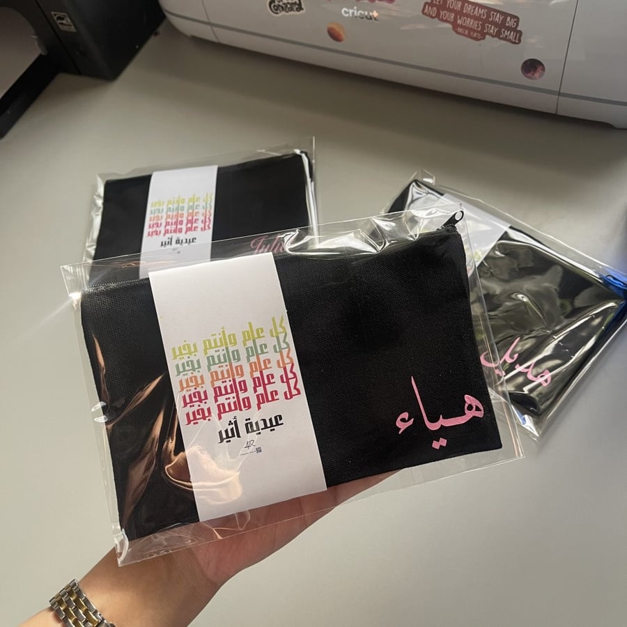شنطة بلون اسود مع طباعة الاسم والتغليف والكرت