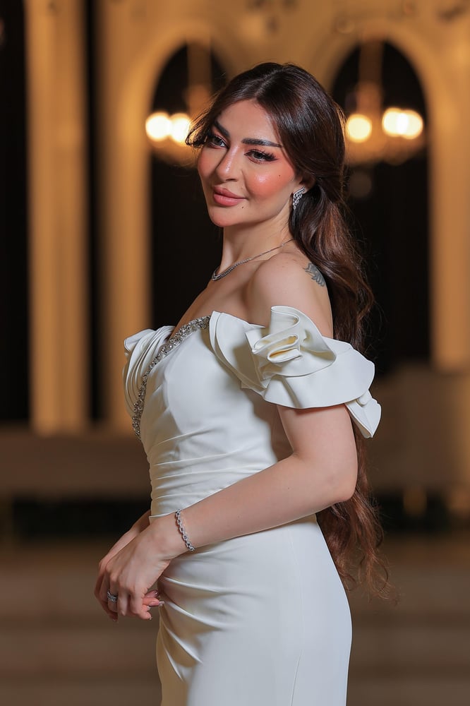 فستان  أنيق وفخم، يتميز بتصميم طويل بلون أبيض ناصع يضفي لمسة من الرقي والصفاء