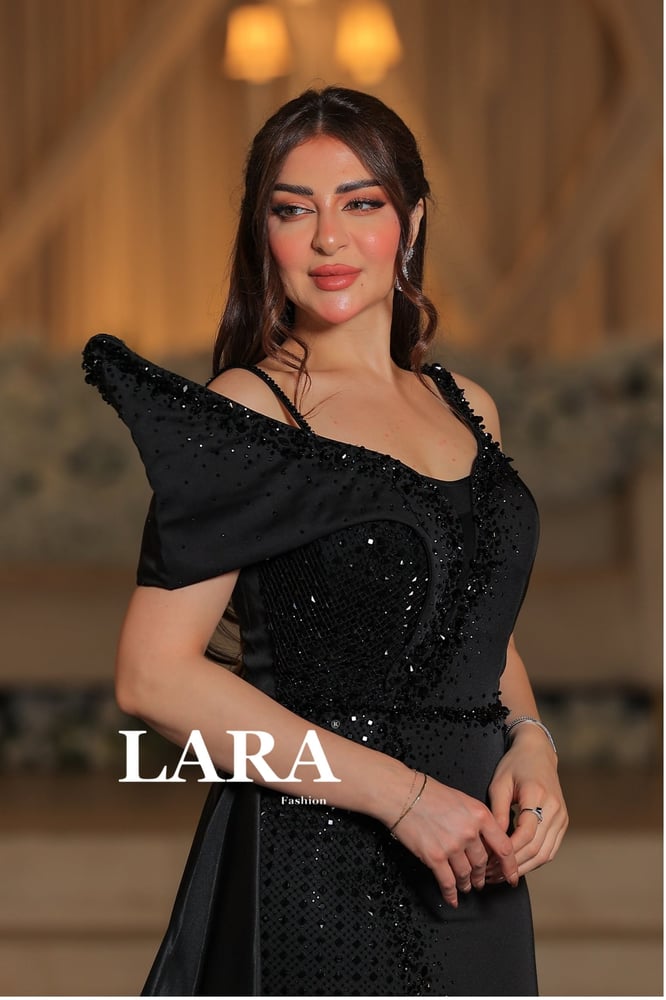 "فستان اسود فاخر بلمسات ترتر فخمة وتصميم مميز على الكتف