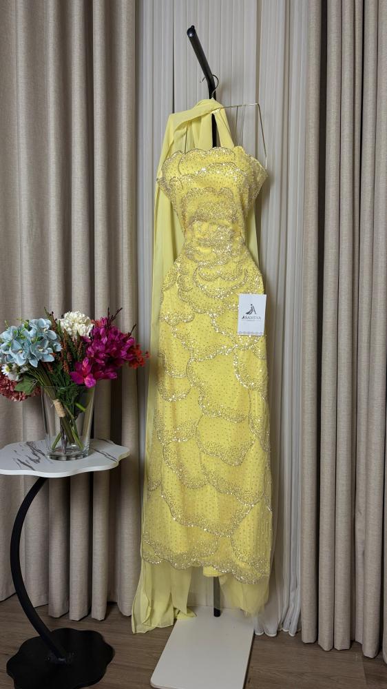 A yellow dress with a lining, a torn hem, and embroidered.
