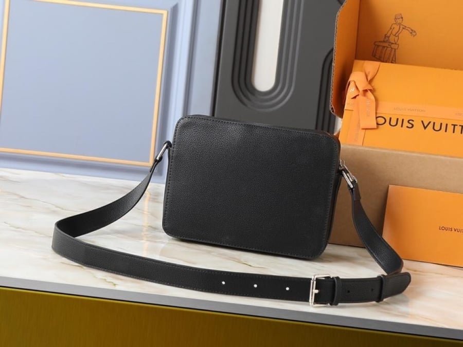 شنطة Louis Vuitton باللون الأسود بتصميم كروس صغير ونقشة Monogram، مع تفاصيل متباينة وإبزيمين بارزين في الواجهة. تصميمها المنظم وحزام الكتف الطويل يمنحانها مظهرًا عصريًا سهل التنسيق، بينما تضيف التفاصيل الأمامية لمسة لافتة تناسب الإطلالات اليومية بدرجاتها