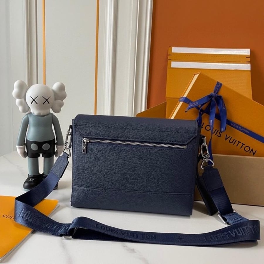 شنطة كروس Louis Vuitton بدرجة بيج هادئة وتصميم مستطيل بسيط، مع شعار LV بارز في الواجهة وحزام كتف عريض. يمنحها اللون المحايد مظهرًا راقيًا وهادئًا، ويسهل تنسيقها مع درجات الأبيض والبني والألوان الترابية لإطلالة يومية أنيقة.