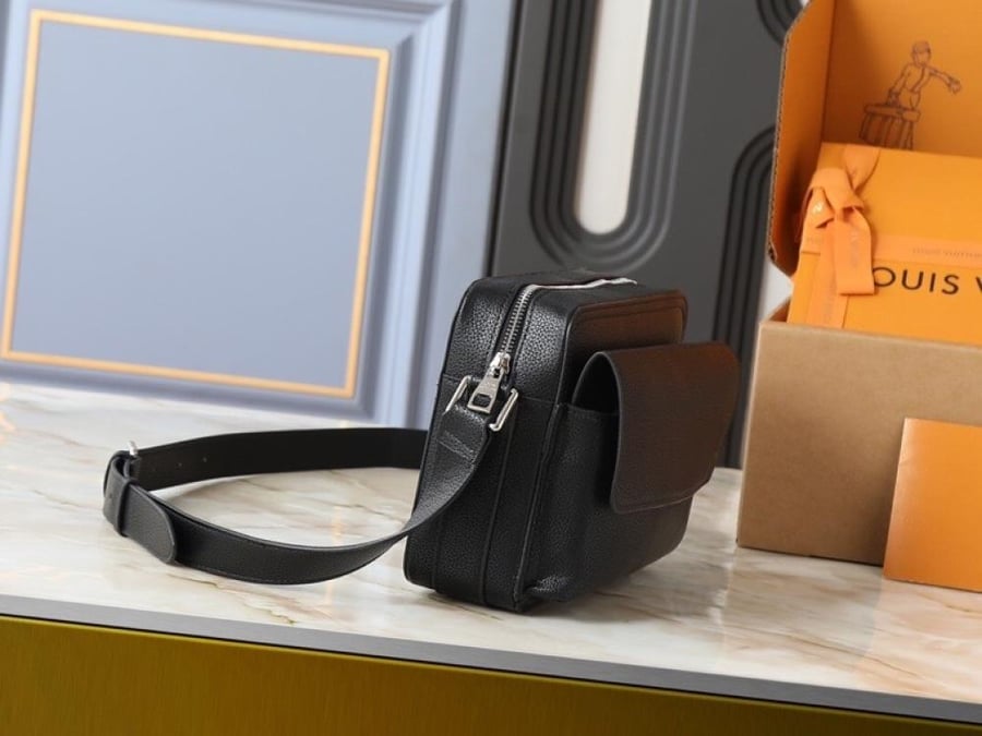 شنطة Louis Vuitton باللون الأسود بتصميم كروس صغير ونقشة Monogram، مع تفاصيل متباينة وإبزيمين بارزين في الواجهة. تصميمها المنظم وحزام الكتف الطويل يمنحانها مظهرًا عصريًا سهل التنسيق، بينما تضيف التفاصيل الأمامية لمسة لافتة تناسب الإطلالات اليومية بدرجاتها