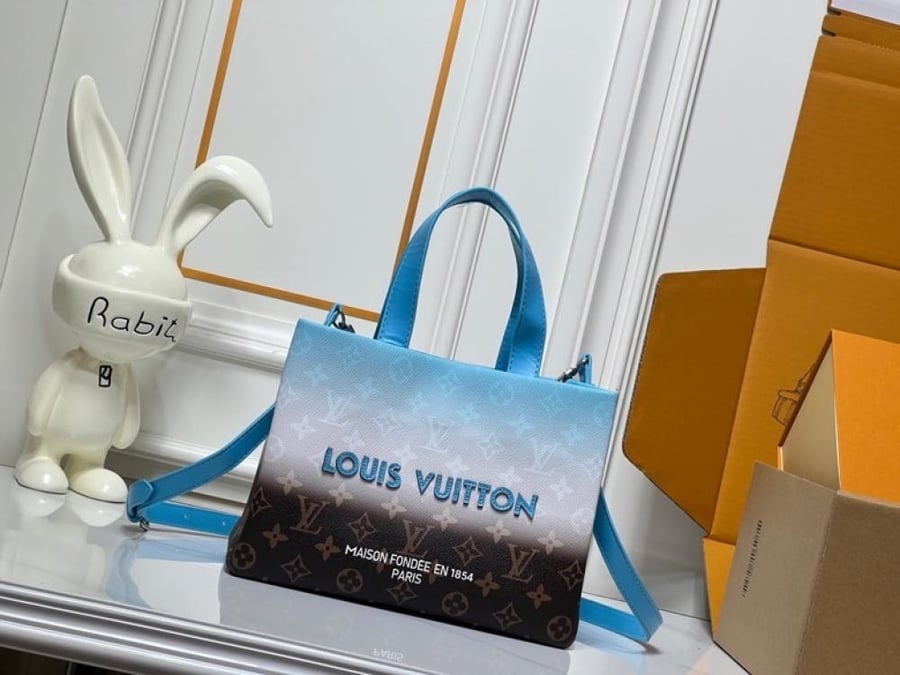 شنطة يد Louis Vuitton بنقشة مربعات تجمع بين الرمادي والأسود،