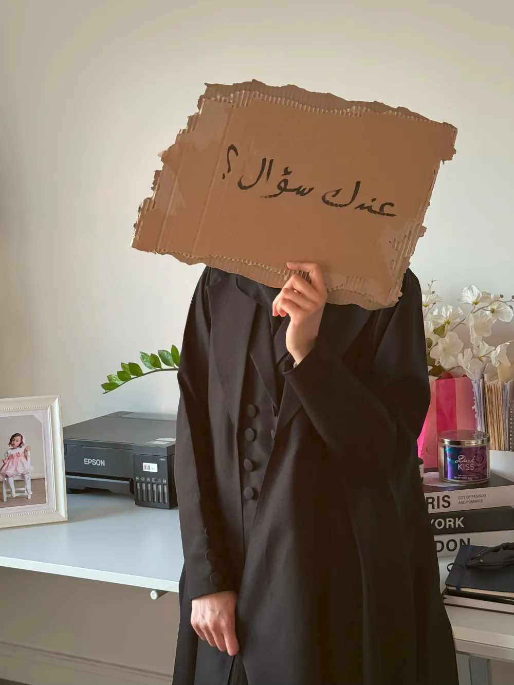 عندك سؤال؟ موظفة ميار ميموريز تحمل لافتة بجانب طابعة الصور