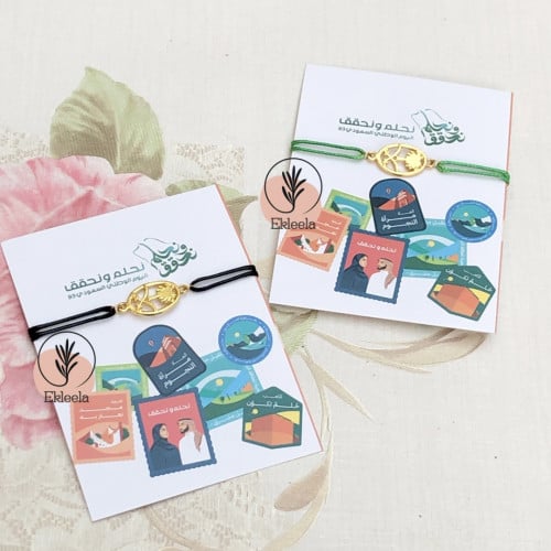 توزيعات اساور  مع ثيم ورقي عن اليوم الوطني نحلم ونحقق  ( 12 قطعه )