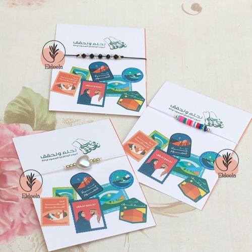 توزيعات اساور  مع ثيم ورقي عن اليوم الوطني نحلم ونحقق  ( 12 قطعه )