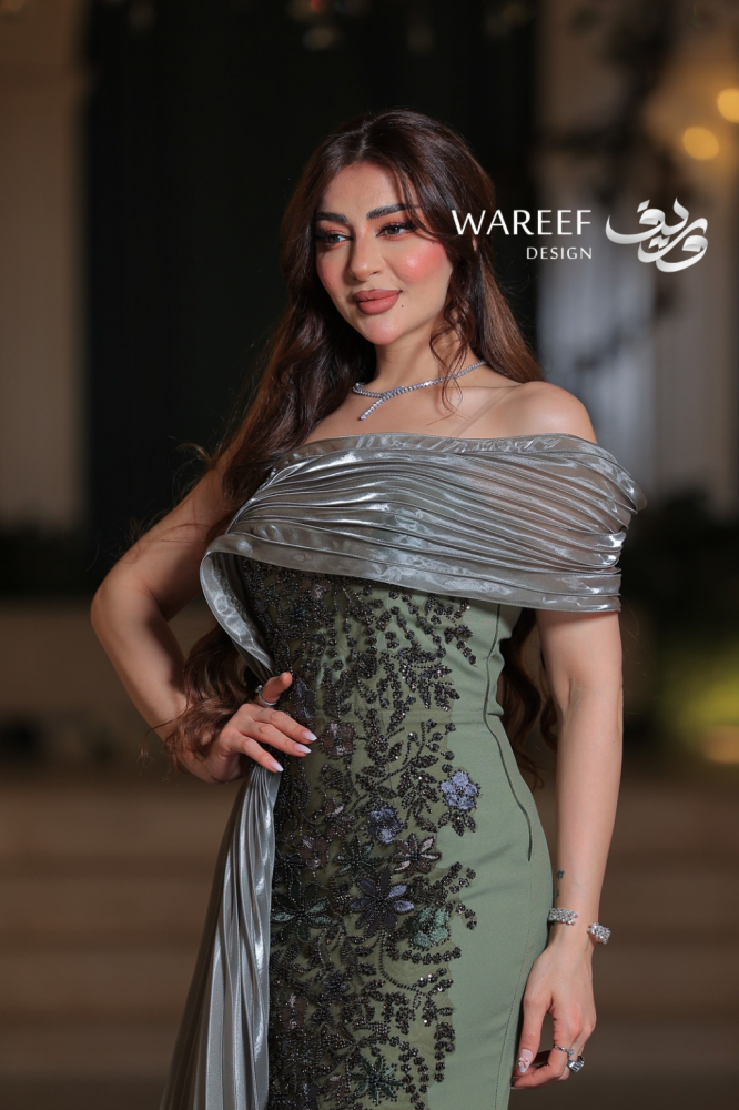 فستان سهرة زيتي طويل من التفتة والتول بتصميم وان شولدر مع ذيل مطرز وزهور يدوية