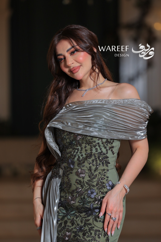 فستان سهرة زيتي طويل من التفتة والتول بتصميم وان شولدر مع ذيل مطرز وزهور يدوية