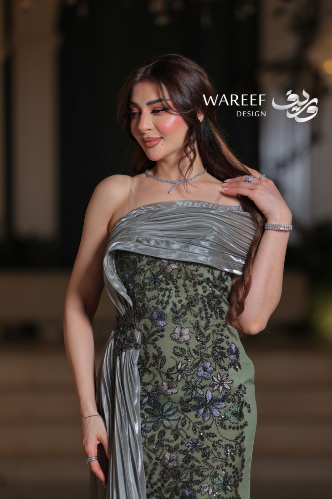 فستان سهرة زيتي طويل من التفتة والتول بتصميم وان شولدر مع ذيل مطرز وزهور يدوية