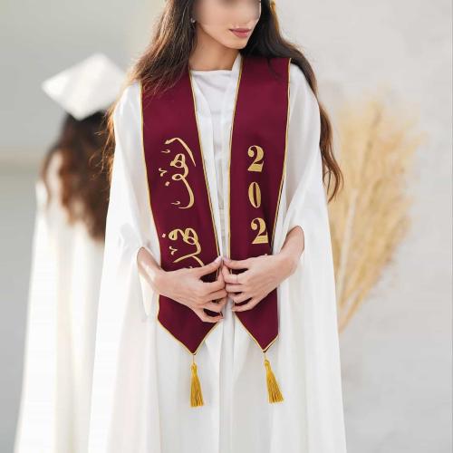 عبايات تخرج 2026 بيضاء مع وشاح أحمر مطرز بالاسم