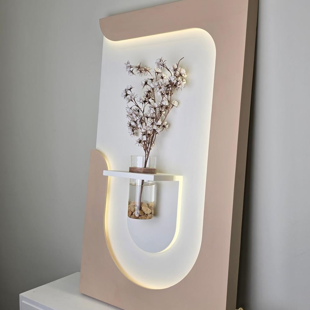 لوحة جدارية خشبية تحتوي على ليد مضئ تتوسطها مزهرية زجاجية