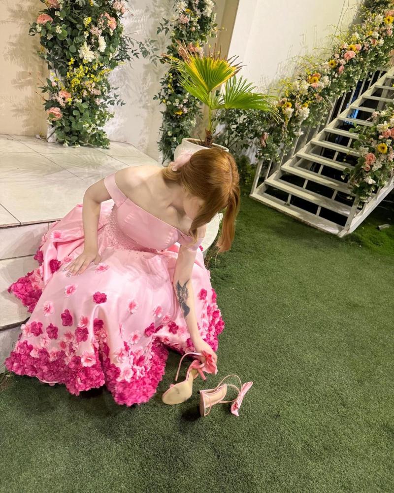 فستان سهرة أنيق باللون الوردي، يتميز بتصميم "أوف شولدر" (بدون أكتاف) يبرز جمال الأكتاف