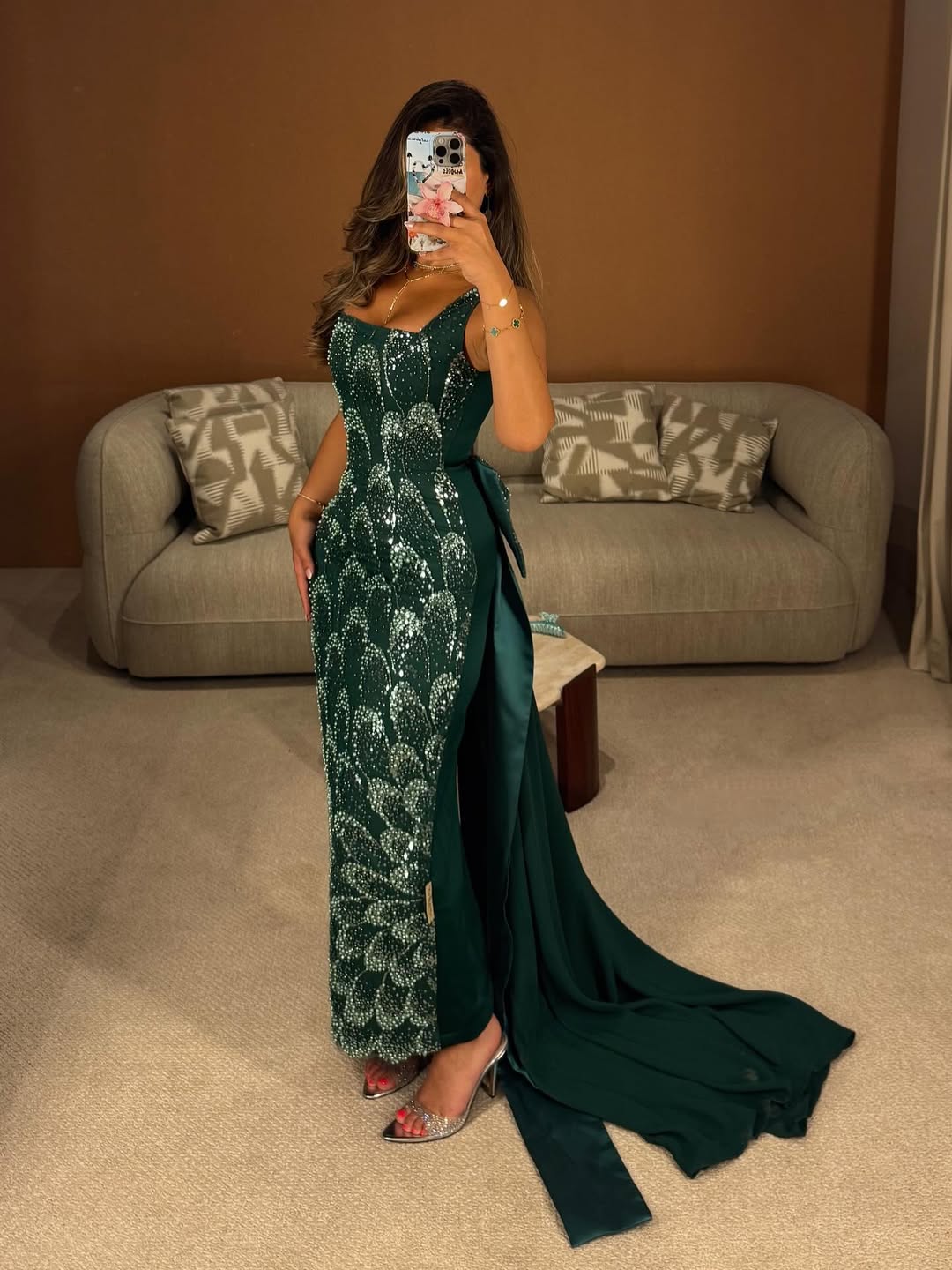 فستان سهرة طويل بلون أخضر زمردي، مزين بالكامل بالترتر أو الخرز اللامع بتصميم يشبه قشور السمك أو الريش