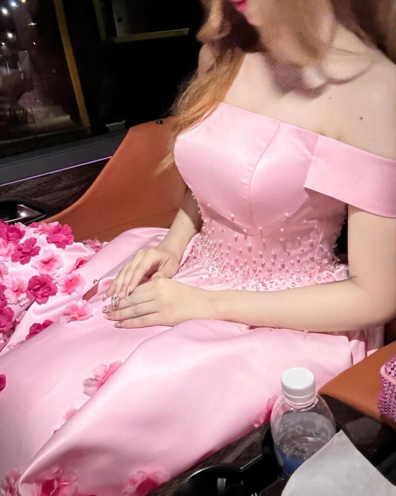 فستان سهرة أنيق باللون الوردي، يتميز بتصميم "أوف شولدر" (بدون أكتاف) يبرز جمال الأكتاف