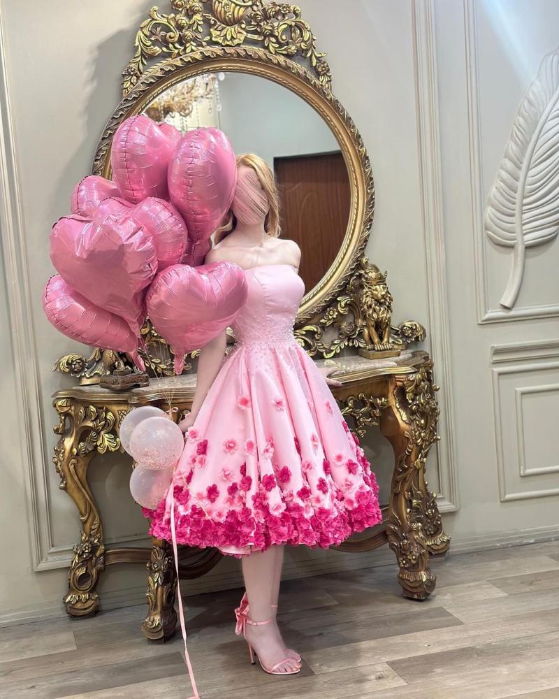 فستان سهرة أنيق باللون الوردي، يتميز بتصميم "أوف شولدر" (بدون أكتاف) يبرز جمال الأكتاف