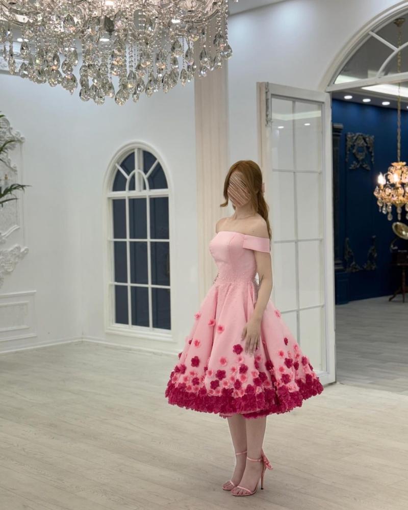 فستان سهرة أنيق باللون الوردي، يتميز بتصميم "أوف شولدر" (بدون أكتاف) يبرز جمال الأكتاف