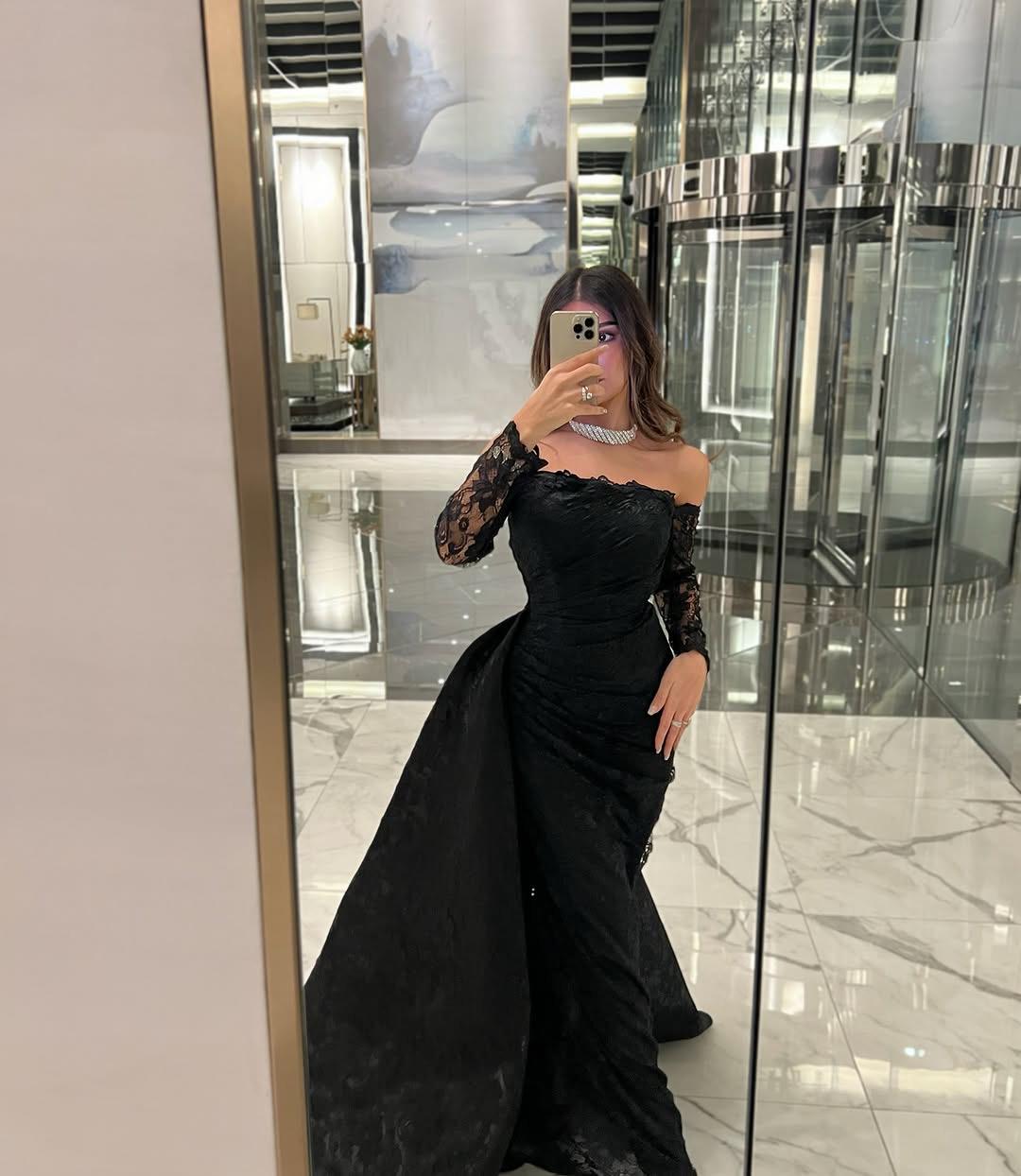 فستان سهرة طويل باللون الأسود، يتميز بتصميم أنيق وفاخر.