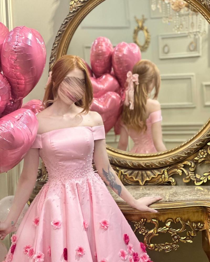 فستان سهرة أنيق باللون الوردي، يتميز بتصميم "أوف شولدر" (بدون أكتاف) يبرز جمال الأكتاف