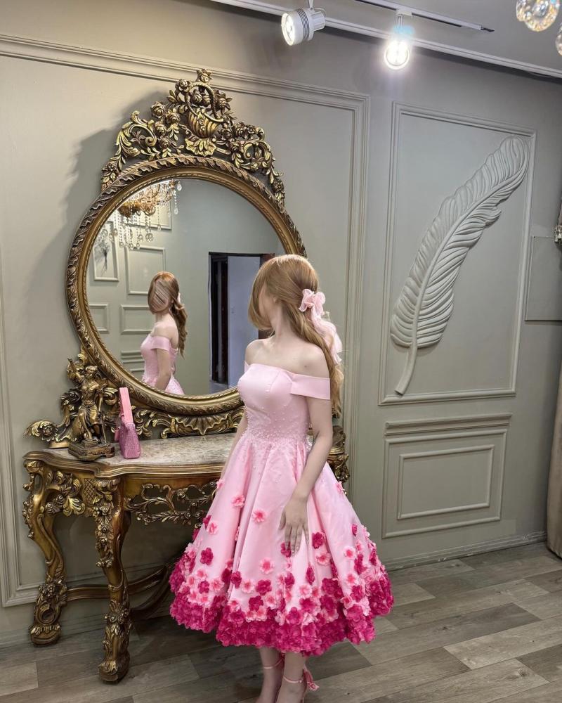 فستان سهرة أنيق باللون الوردي، يتميز بتصميم "أوف شولدر" (بدون أكتاف) يبرز جمال الأكتاف