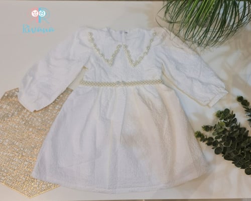 فستان ابيض مزين باللؤلؤ وحزام خارج من اللؤلؤ