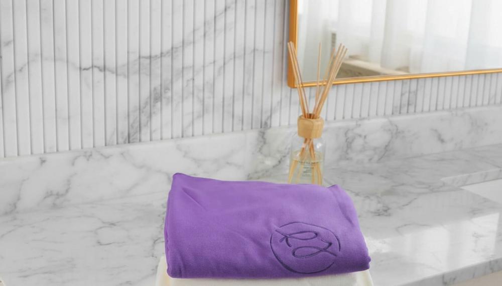 مناشف لا تسبب حساسية منشفة بنفسجية مطوية على سطح رخامي للاستخدام يومي