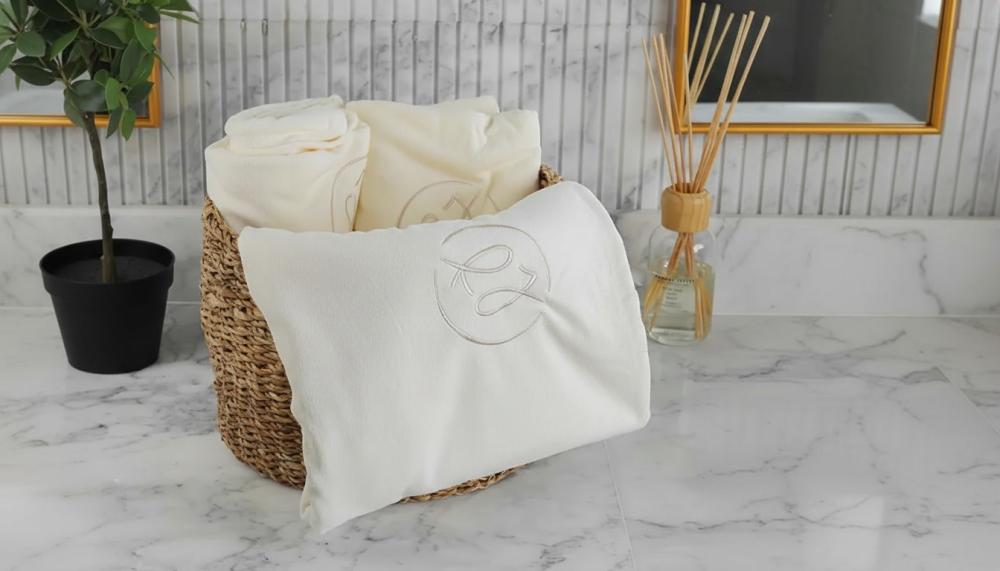سلة مناشف قطنية داخل حمام هادئ توضح انواع المناشف واستخداماتها