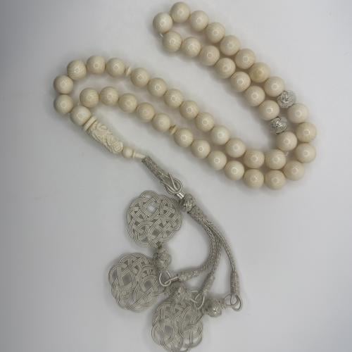 سبحه من عاج الفيل بخرز كروي و شاهد منقوش منظومه بطربزونه فضه بلون فضي فاتح بتصميم حلقي و اطراف ثلاثيه