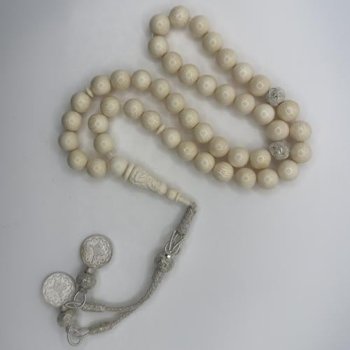 سبحه من عاج الفيل بخرز كروي و شاهد منقوش منظومه بطربزونه فضه بلون فضي فاتح بتصميم يدمج بين الطربزونه و مستوحى من الفضه الحلبيه باطراف ثنائيه